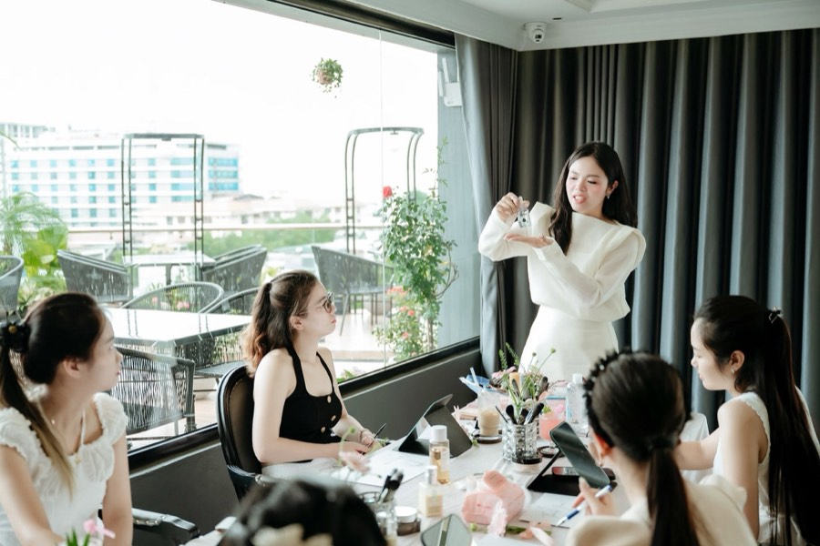 Cella Hương Phượng hướng dẫn lớp makeup cá nhân nhóm nhỏ, cầm sản phẩm giới thiệu cho học viên